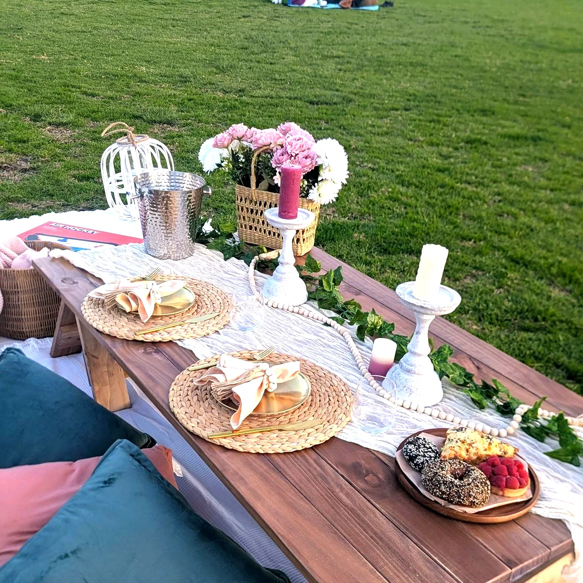 Long picnic table styled with florals and candles on a Sydney waterfront lawn