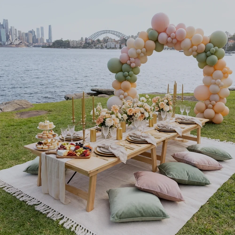 Baby shower picnic for six styled on a Sydney harbourside lawn with a pastel balloon arch