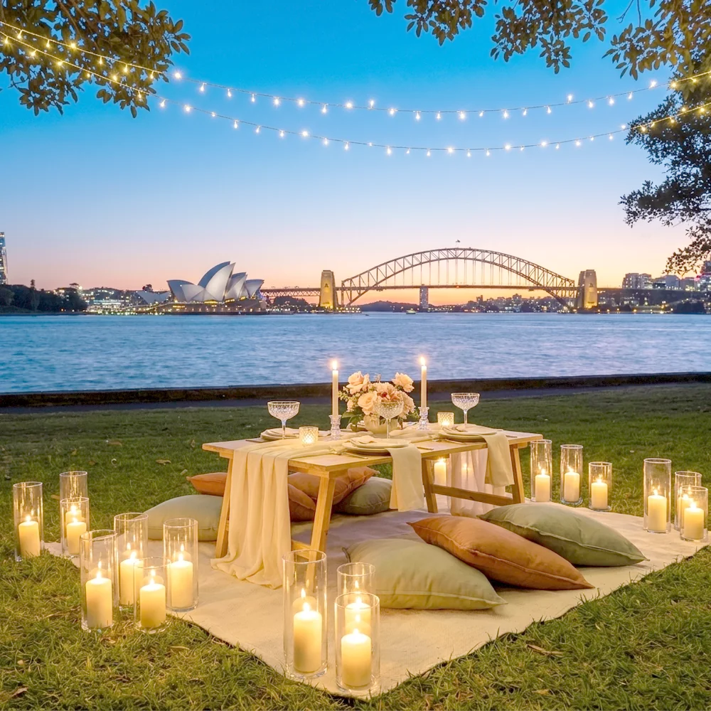Candlelit date night picnic at dusk with glass hurricane lanterns and fairy lights