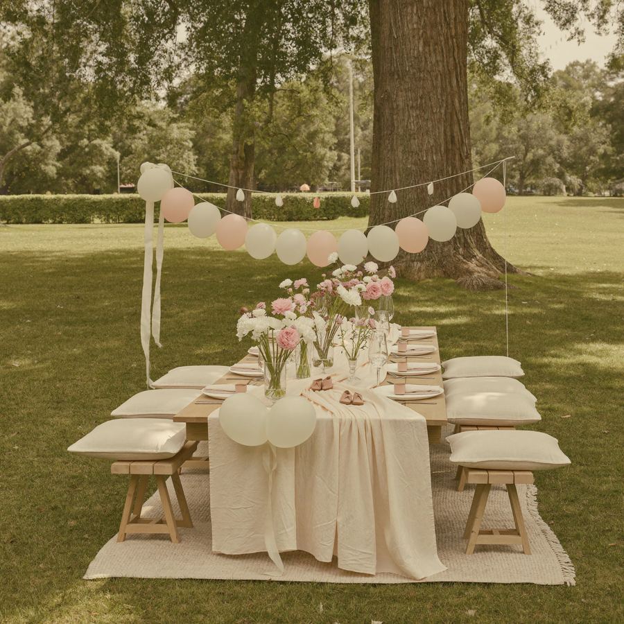 Pastel baby shower picnic setup with balloon garland in a Sydney park
