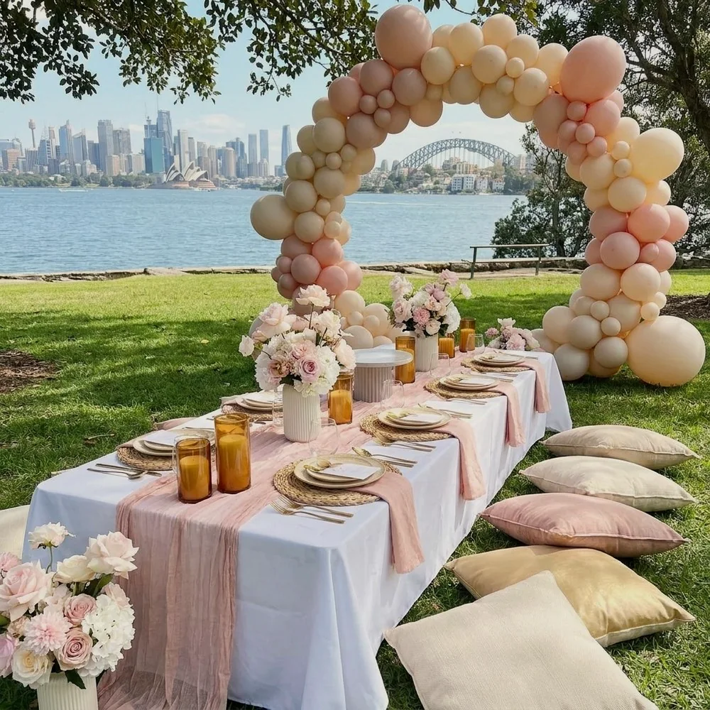 Pastel baby shower picnic setup with balloon garland in a Sydney park