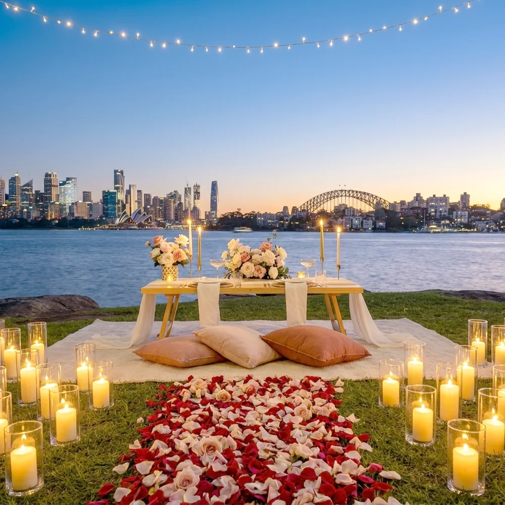 Candlelit proposal picnic at dusk with lanterns and a rose petal pathway, Sydney city skyline behind